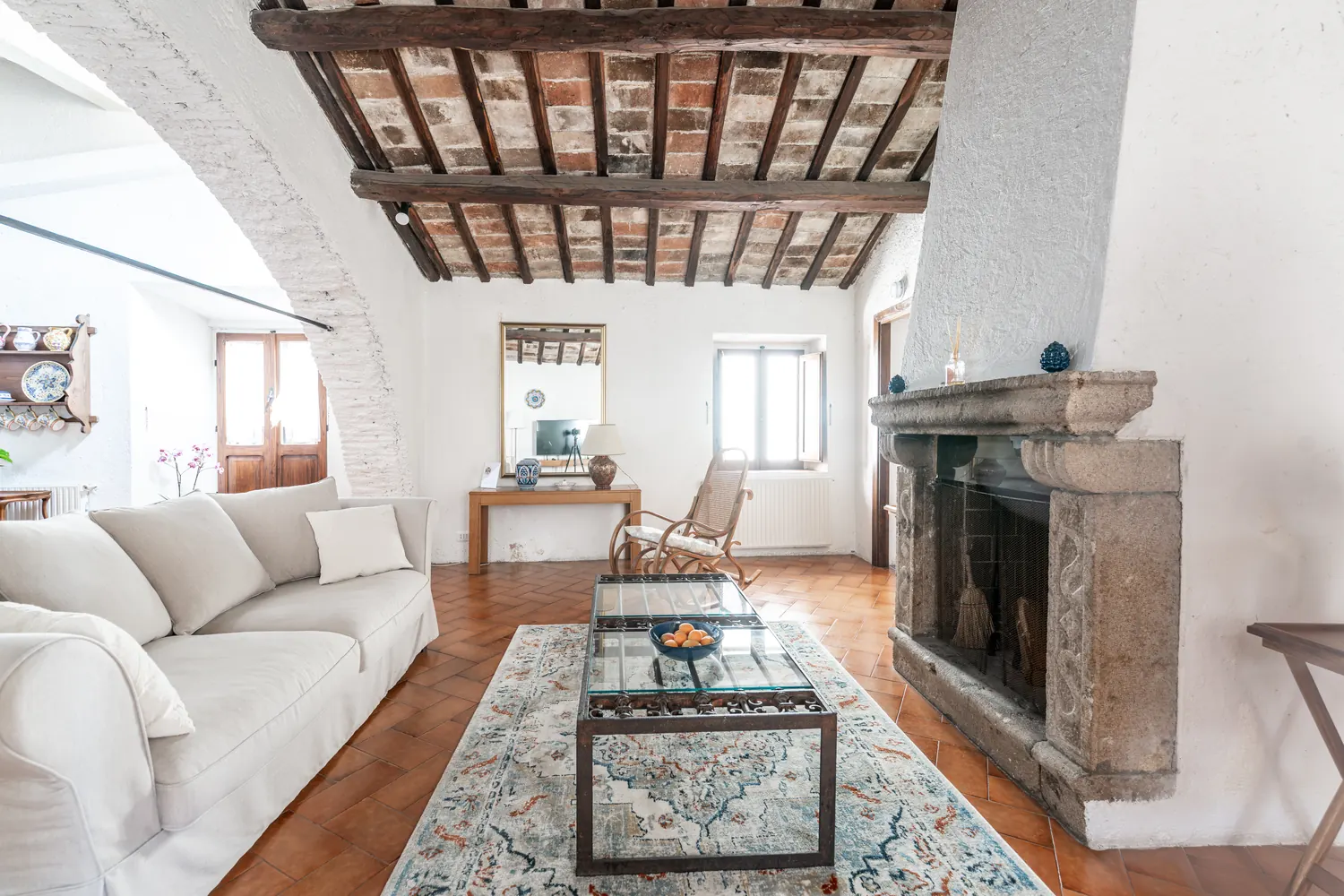 Camino in pietra e salotto sotto il soffitto a travi